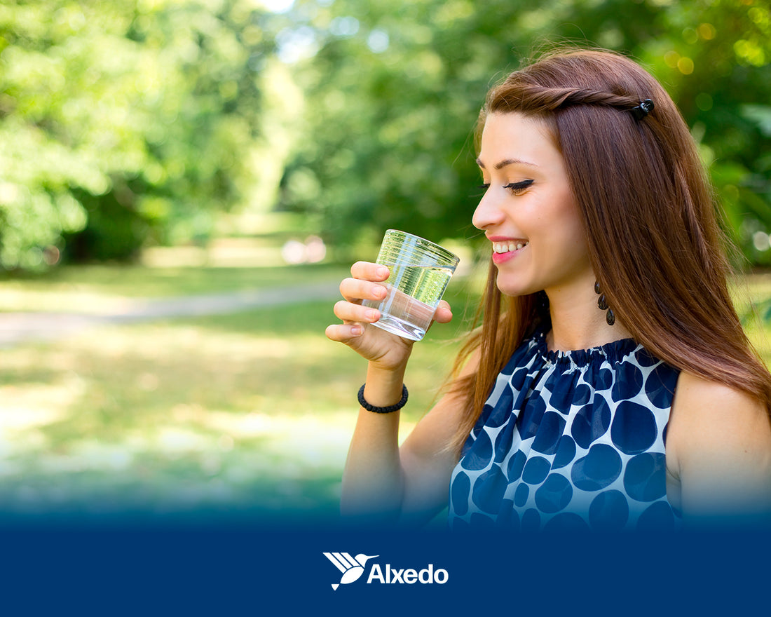 Mujer sonriendo y sosteniendo un vaso de agua